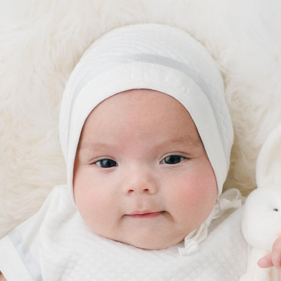 Closeup photo of a newborn baby boy wearing the Owen Quilted Newborn Bonnet