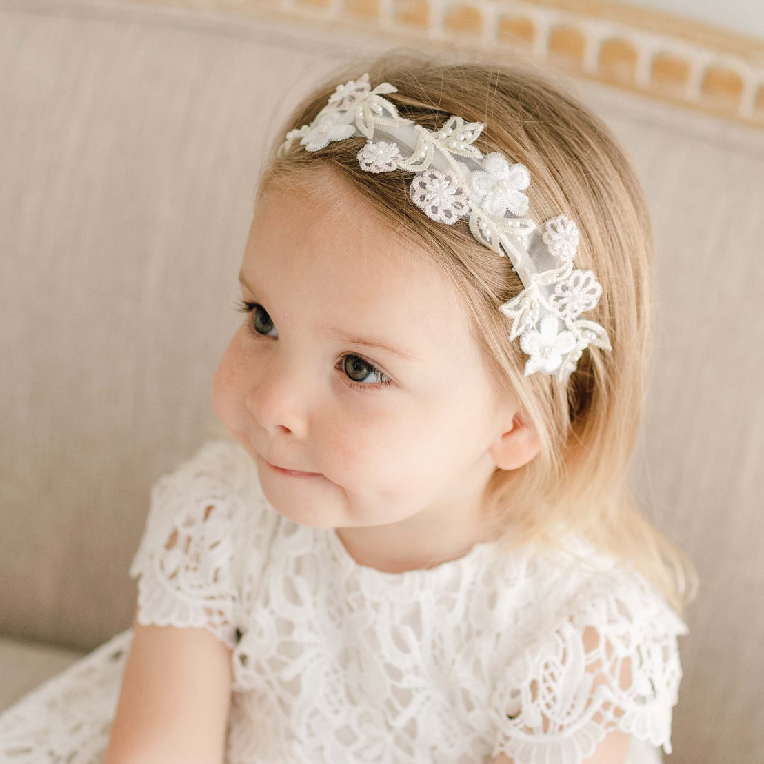 Baby girl wearing a Lola Beaded Flower Headband. Accented with beautiful Lola floral appliqué.