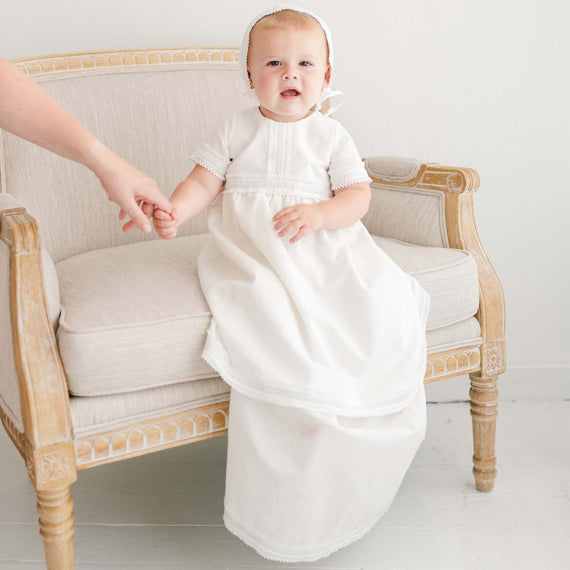 A baby boy wearing a boys baptism gown made of linen. 