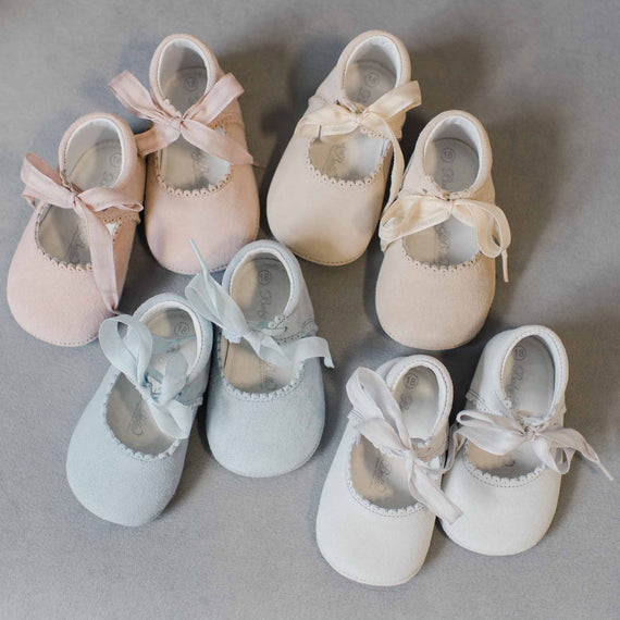 Flat lay photo of the Emily Suede Tie and it's different color variations, including dove grey, sky blue, tan and blush. Shoes are made with a soft suede with tie detail closure.