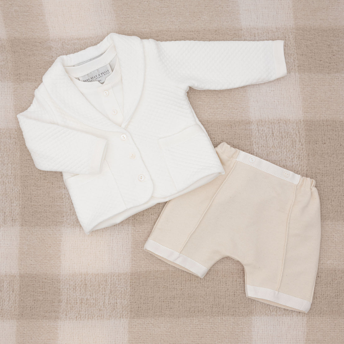 Flat lay photo of the Braden 3-Piece Suit, including the jacket, shorts, and onesie