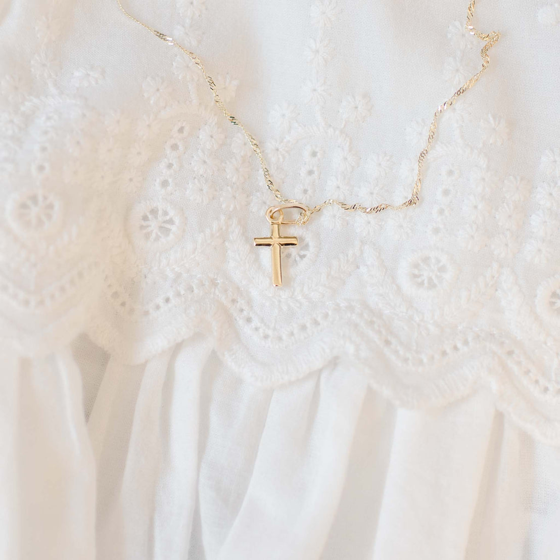 Tiny gold cross charm on chain