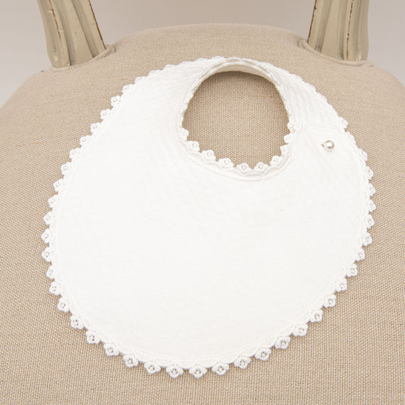 A close-up of a June Bib, displayed on a neutral-toned chair.