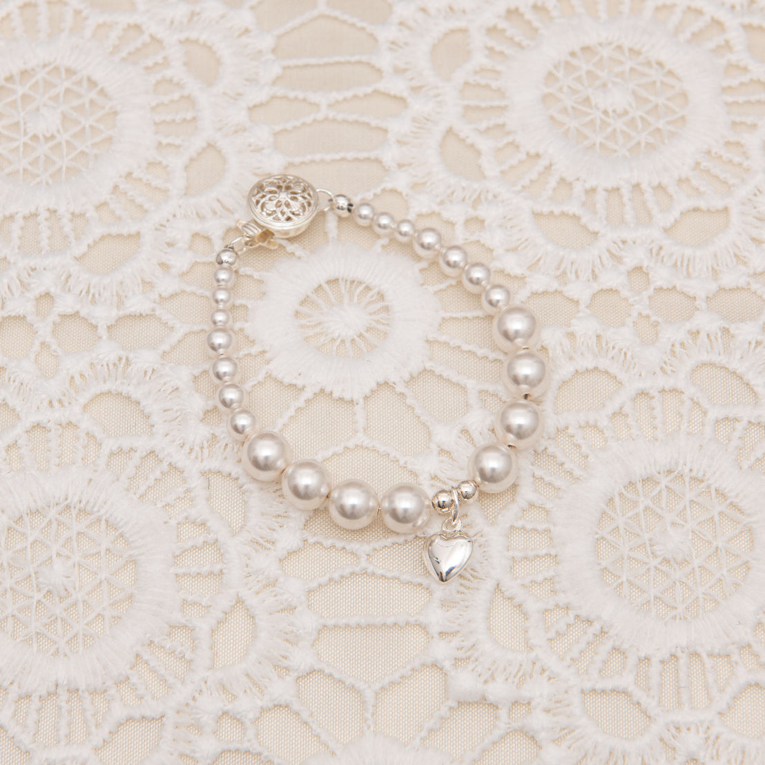 Close up photo of a white luster pearl bracelet. 