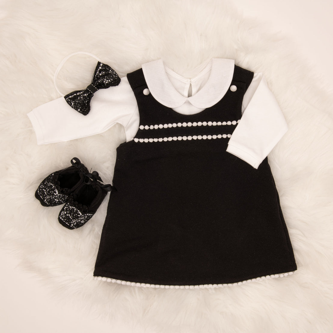 Stylish black and white after-christening June Jumper Dress Set with pearls and sequins, white under-shirt, matching sequined headband, and black sequined shoes laid out on a soft, white