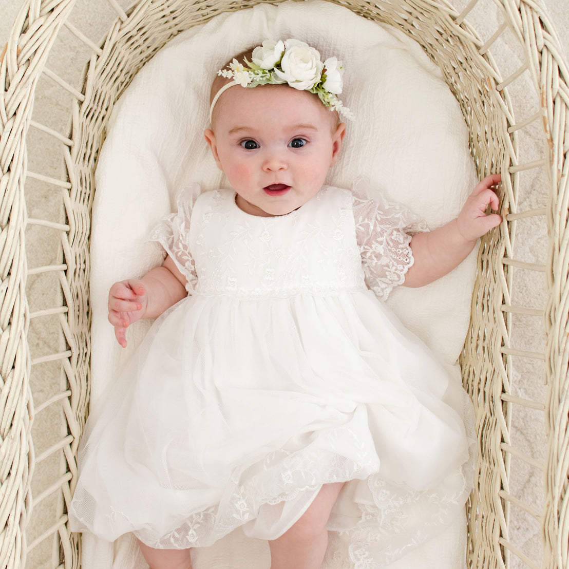 baby girl photographed in crib wearing the Ella baptism lace dress