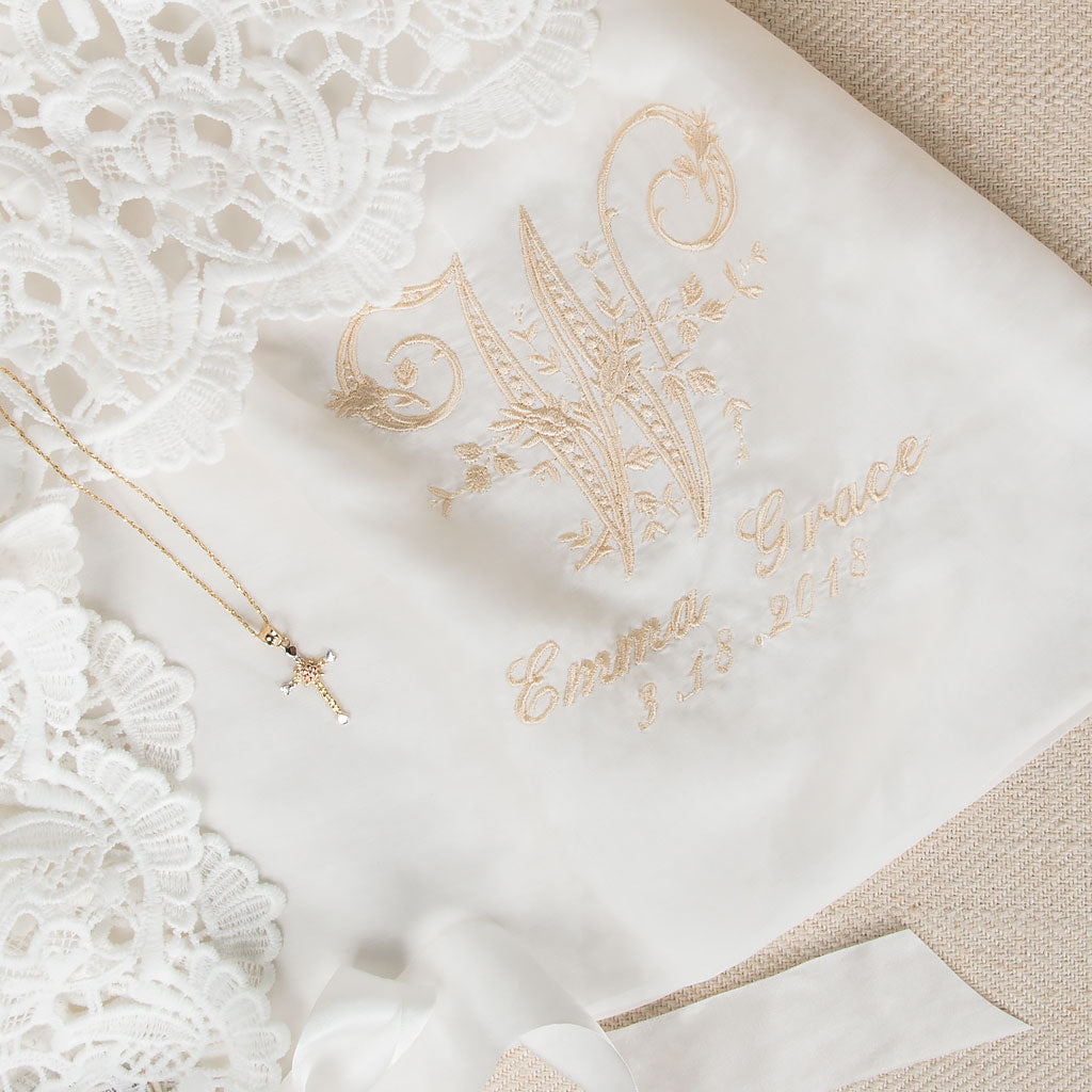 A monogram on the Lola gown with the baby's last initial "W" and the name "Emma Grace" with their birth or christening date.