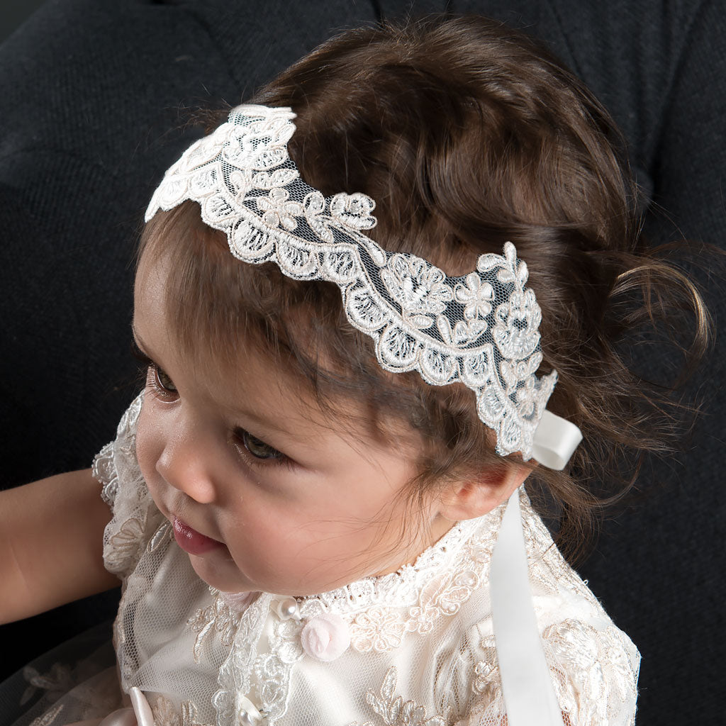 Baby girl wearing the Penelope lace headband in style of a crown.