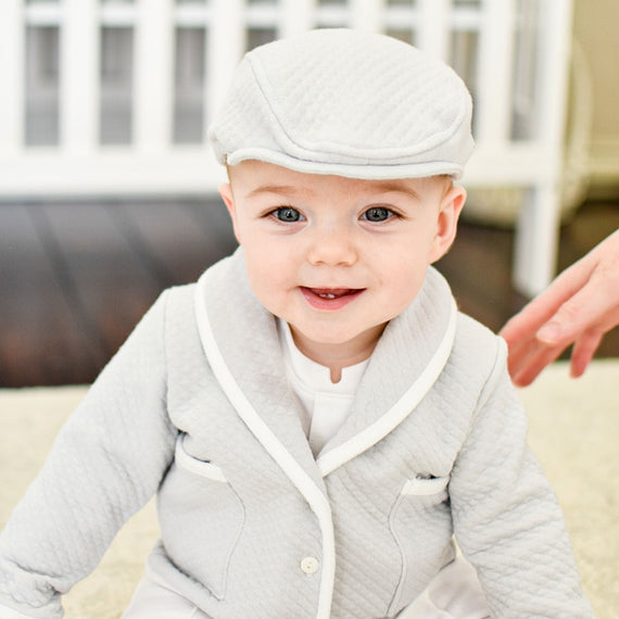Baby boy in Asher baptism suit and newsboy cap. 
