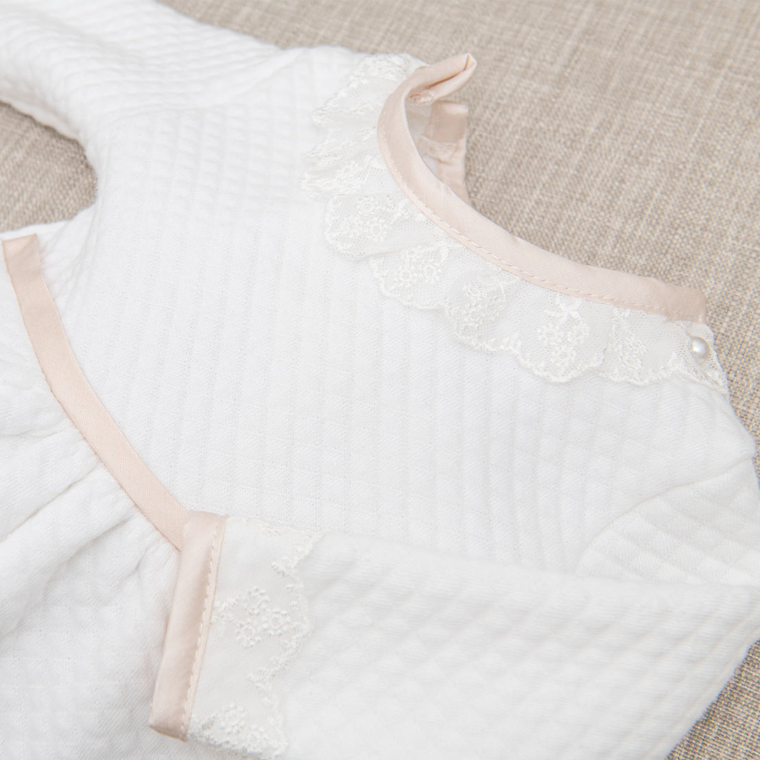 Flat lay photo of the Tessa Quilt Romper showing close up details of the ivory Venice lace along the neck.