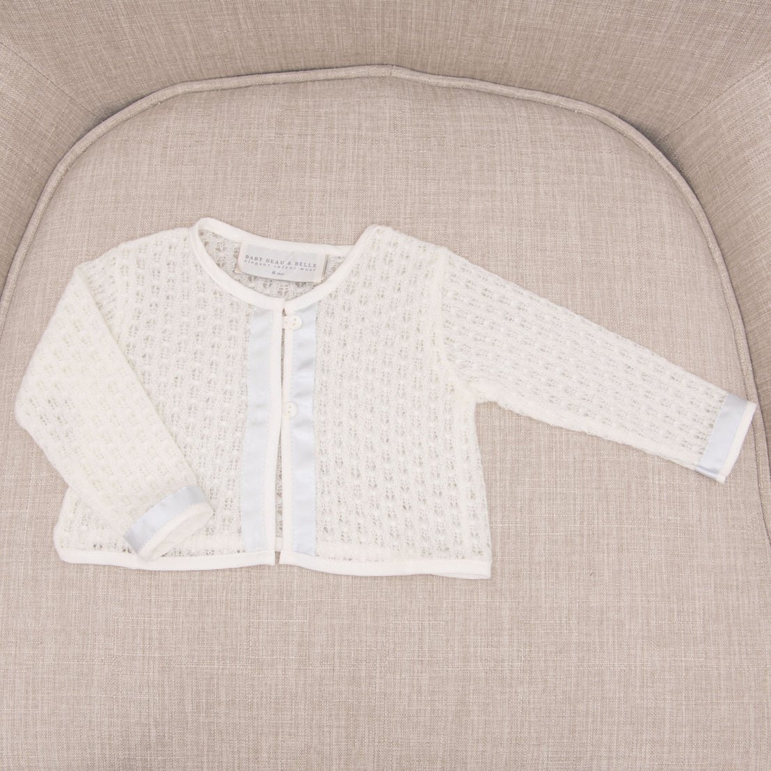 Flat lay photograph of a boys knit baptism sweater. 