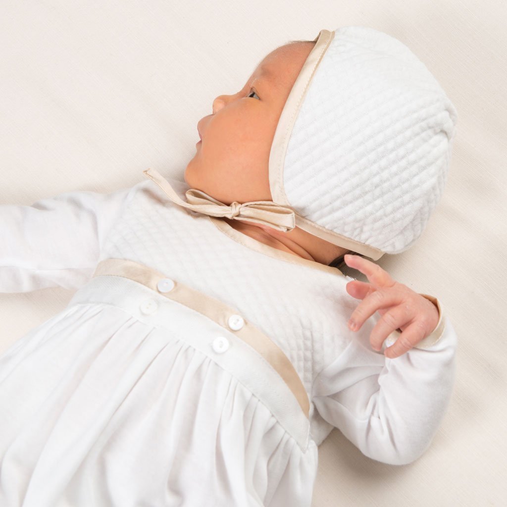 Liam Cotton Close up photo of newborn baby wearing Liam Cotton Newborn Gown. The photo showcases the Liam Quilted Newborn Bonnet