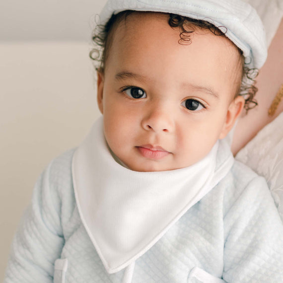 Baby boy wearing the Asher Bandana Bib made from a white French Terry cotton with button closure.