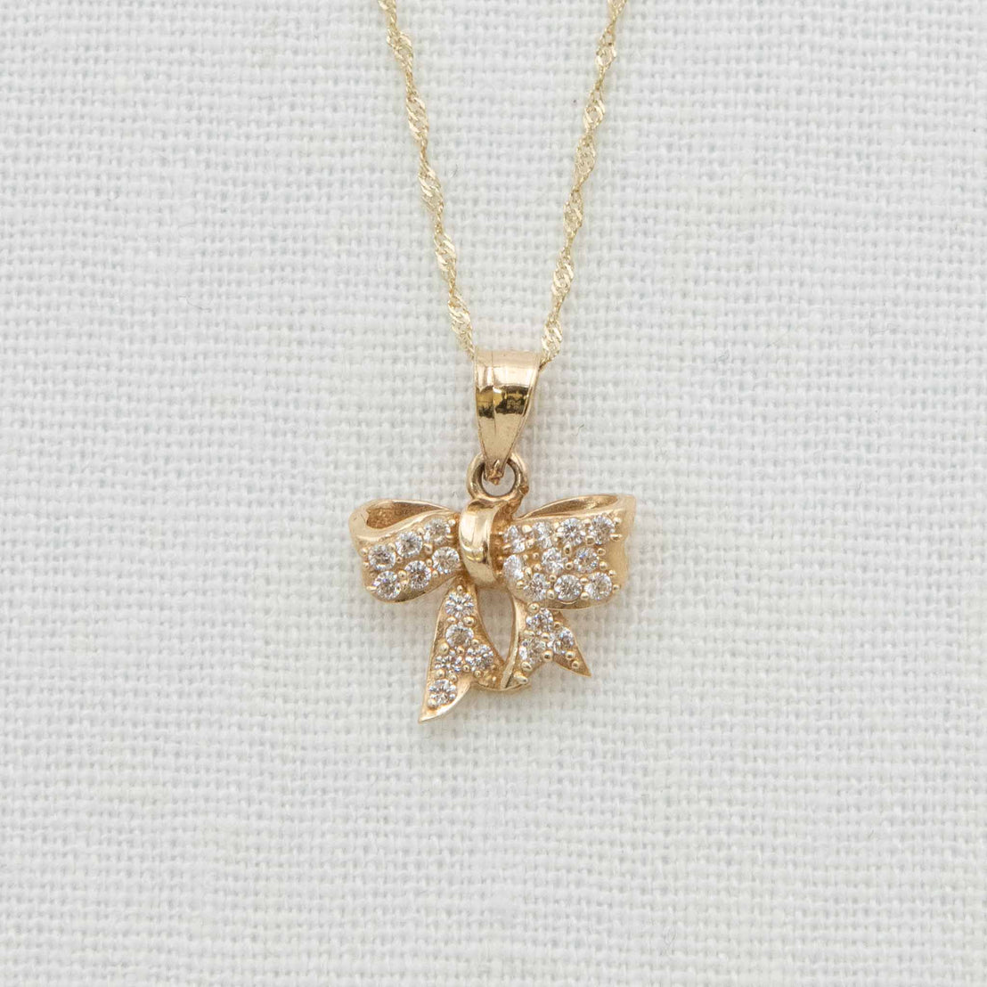 Solid gold bow charm with crystal details on chain