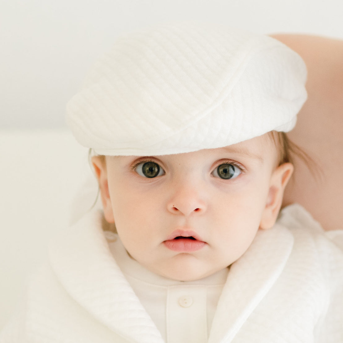 Baby boy wearing the Braden Newsboy Cap made from white quilt