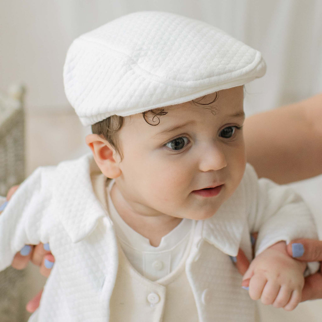 Baby boy in textured ivory cotton cap and jacket