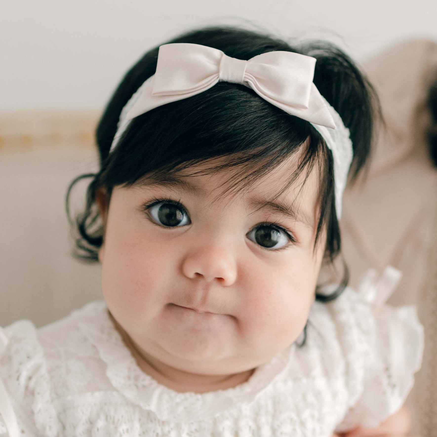 A delicate pink champagne-colored silk bow tied in the center of a Charlotte Accessory Bundle - Save 15%, positioned on a soft, light background.
