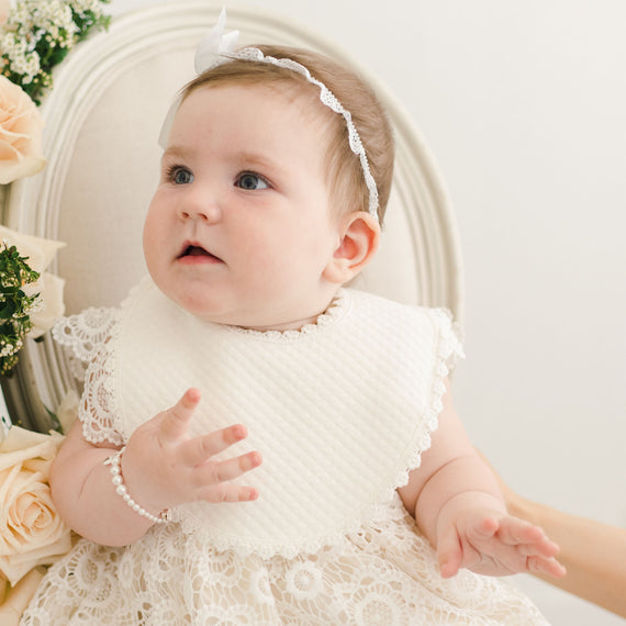 Baby girl wearing christening bib. 