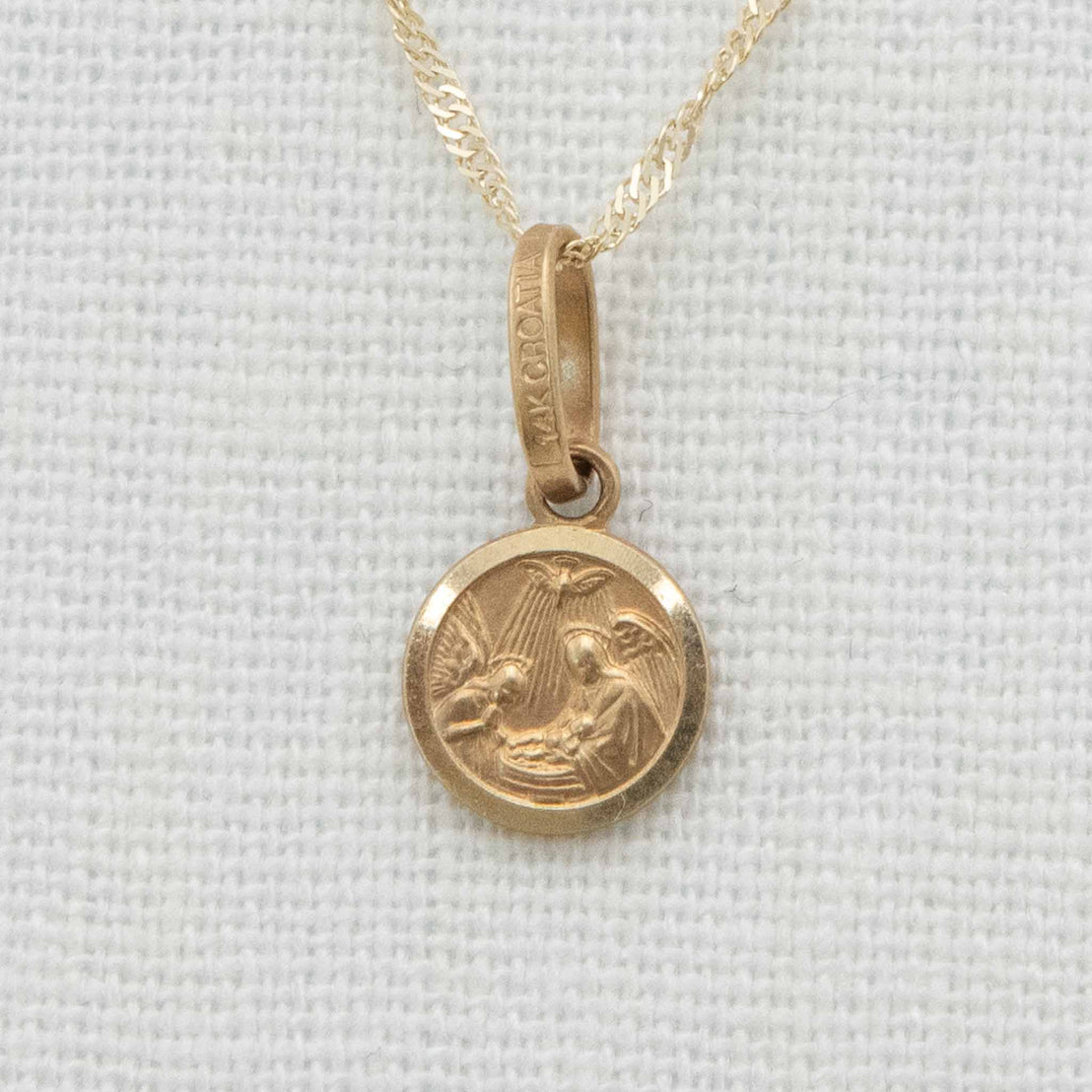 Solid gold round charm with chain depicting baby blessing