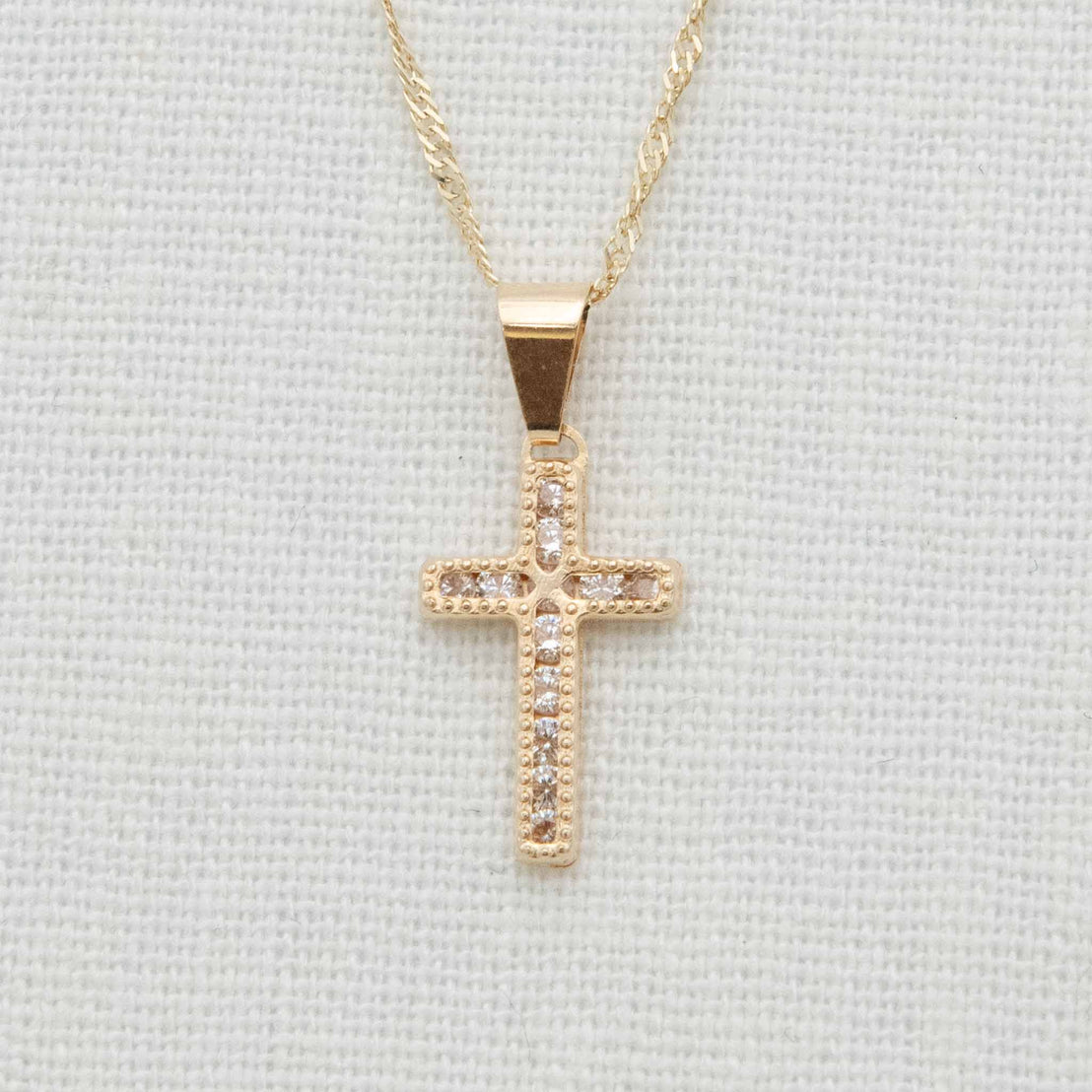 Gold and cubic zirconia cross charm on chain