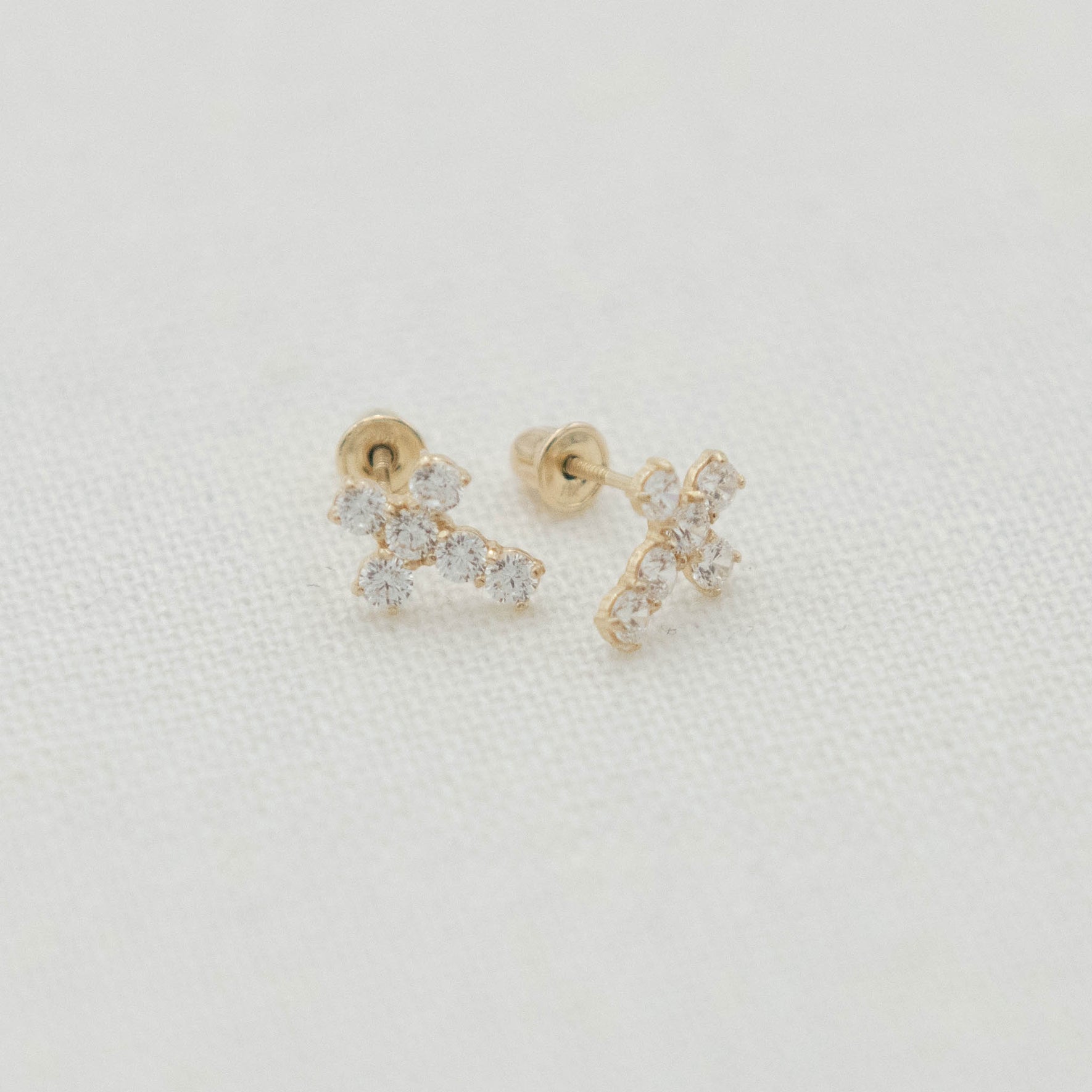 14k Gold & Stone Cross Earrings shown with delicate cross shapes and light-catching stone accents.