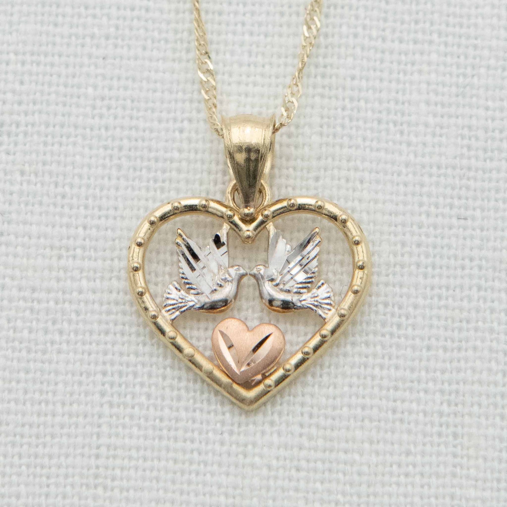 Gold heart with white gold doves and rose gold heart detail on chain