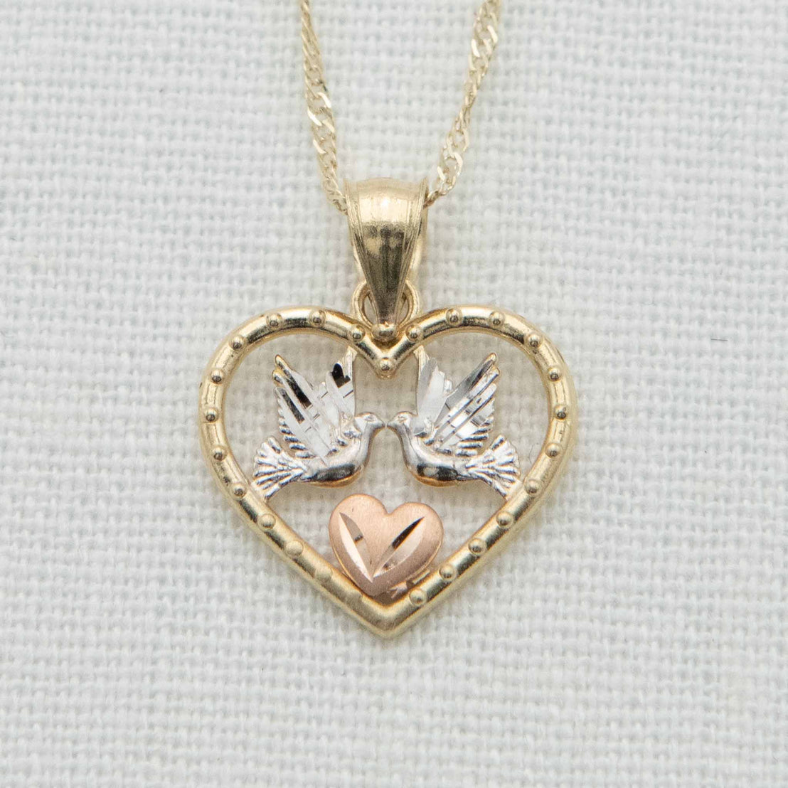 Gold heart with white gold doves and rose gold heart detail on chain