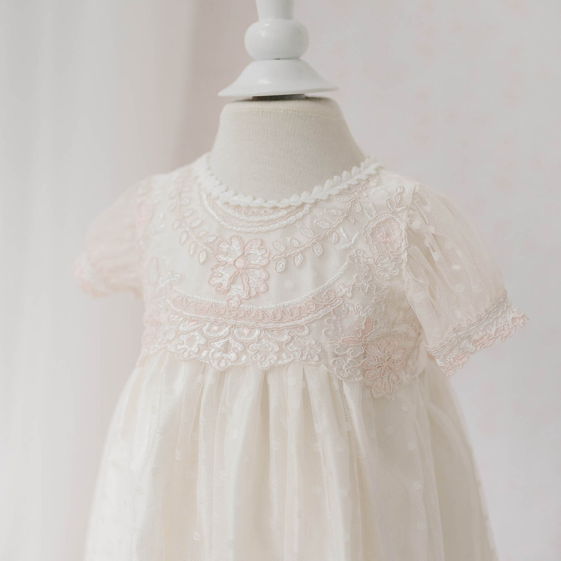 Close-up front view of the Elizabeth Newborn Christening Dress on a mannequin featuring the floral embroidery lace against a white background. Part of the Baby Beau & Belle Baby Girl Christening Dress Collection.