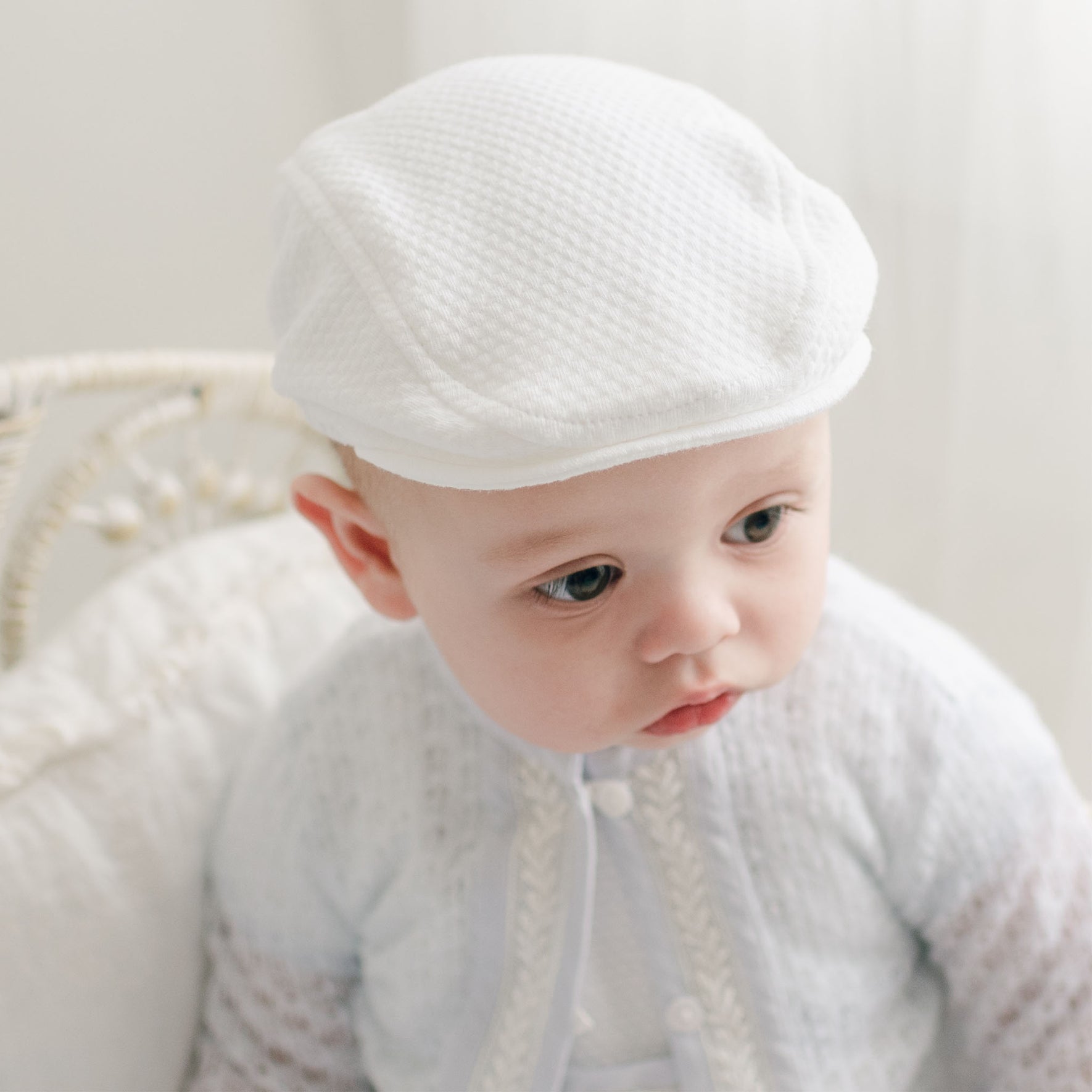 Close-up of the Harrison Textured Christening Newsboy Cap on a baby, displaying its elegant quilted texture and meticulous craftsmanship.