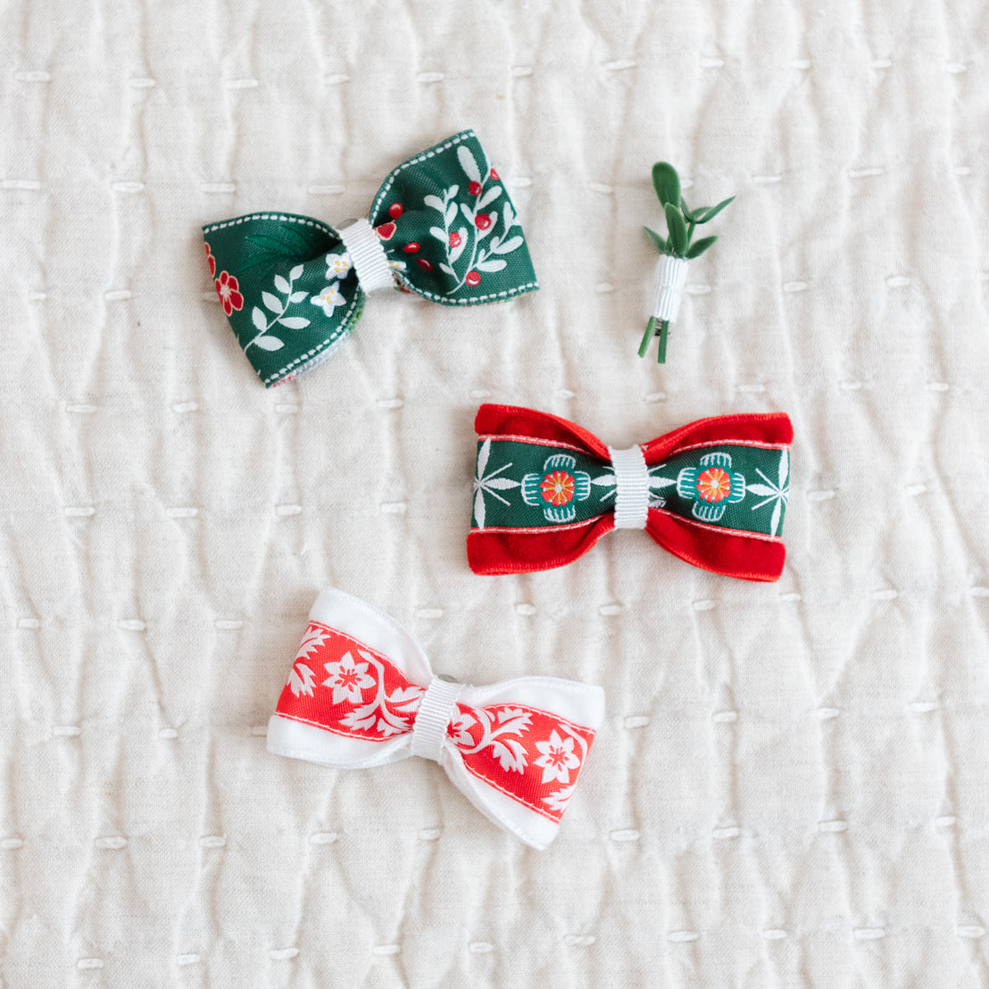 Three decorative bows with floral patterns on a textured white background