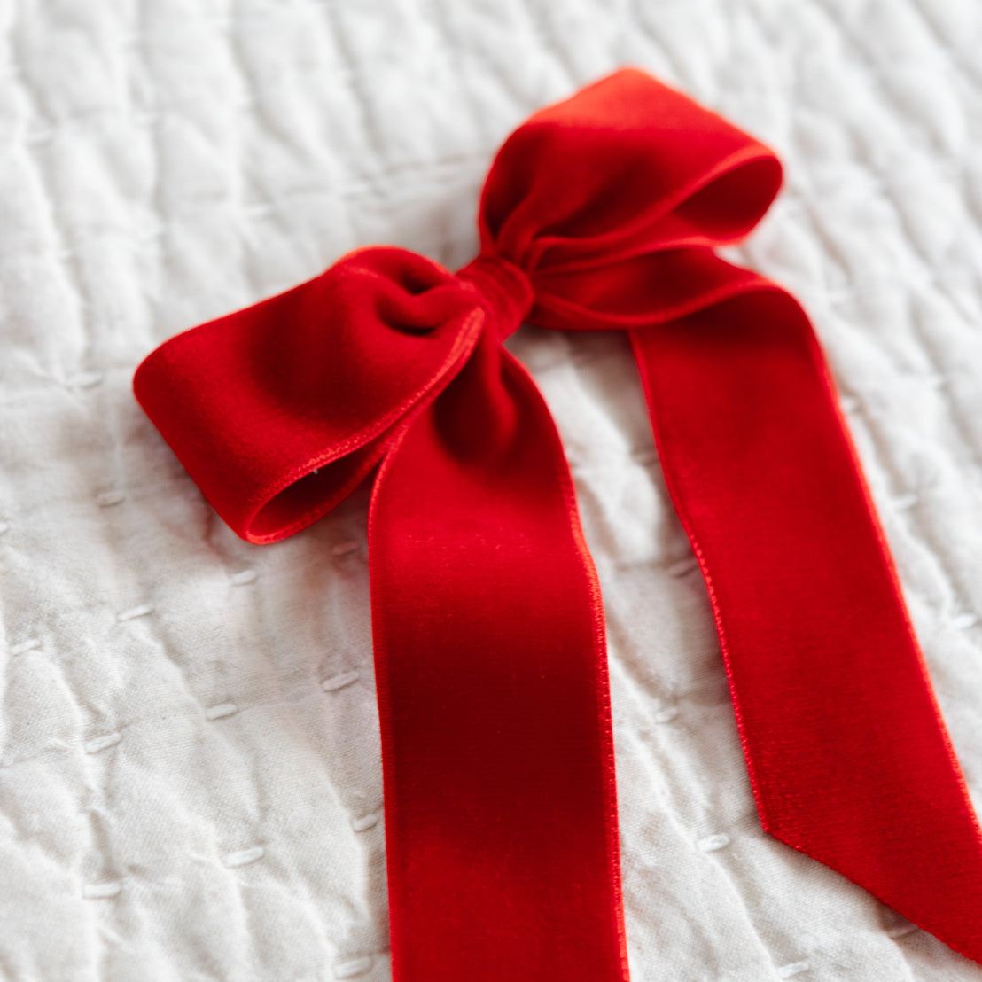 Red velvet bow on a textured white background