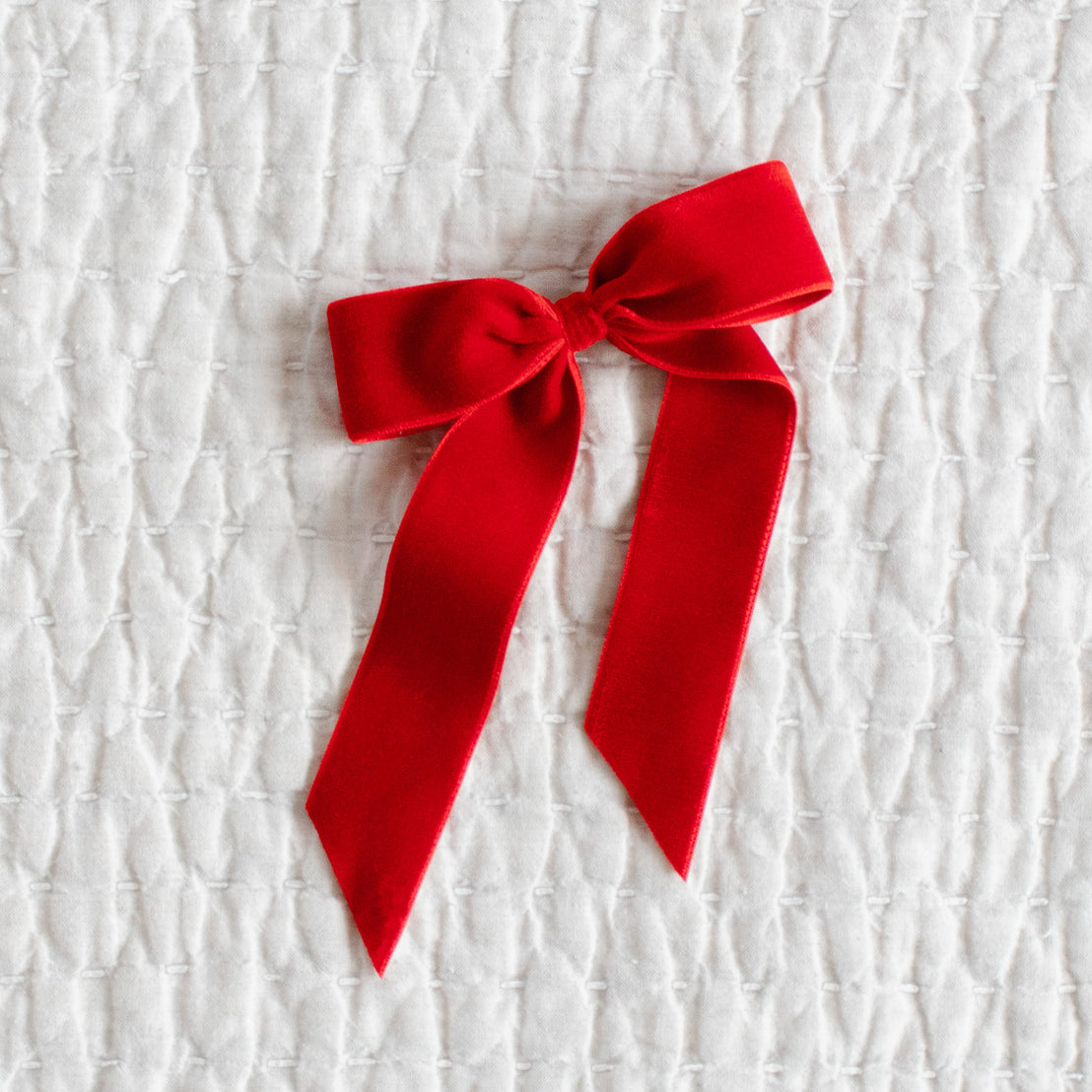 Red velvet bow on a textured white background