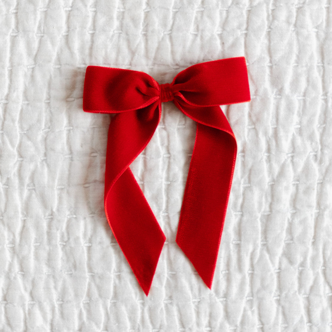 Red velvet bow on a textured white background