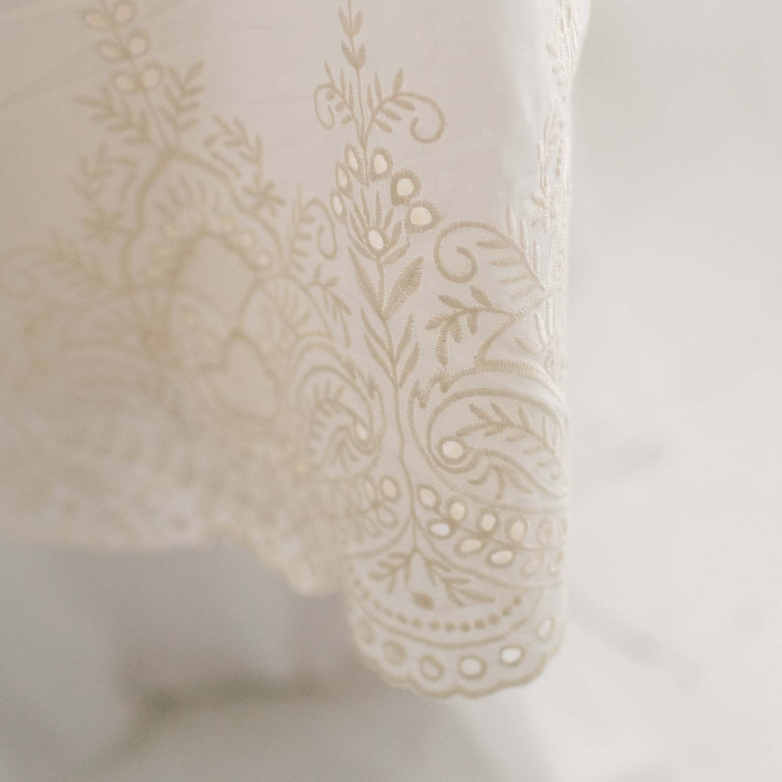 Close up of Ingrid Blessing Gown skirt showcasing the natural embroidery and unique patterns of the elegant tiered skirt
