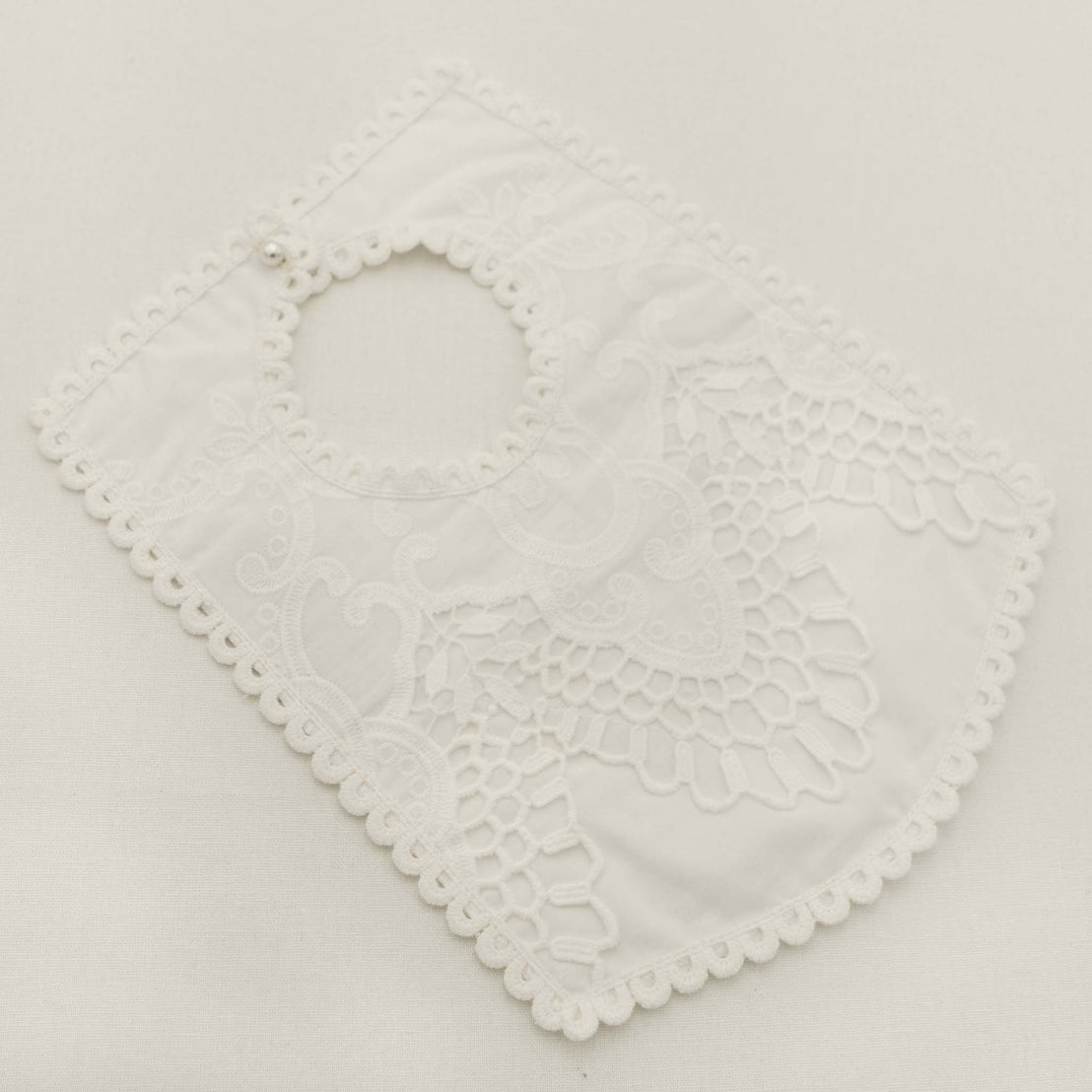Off-white lace bib on a light gray background