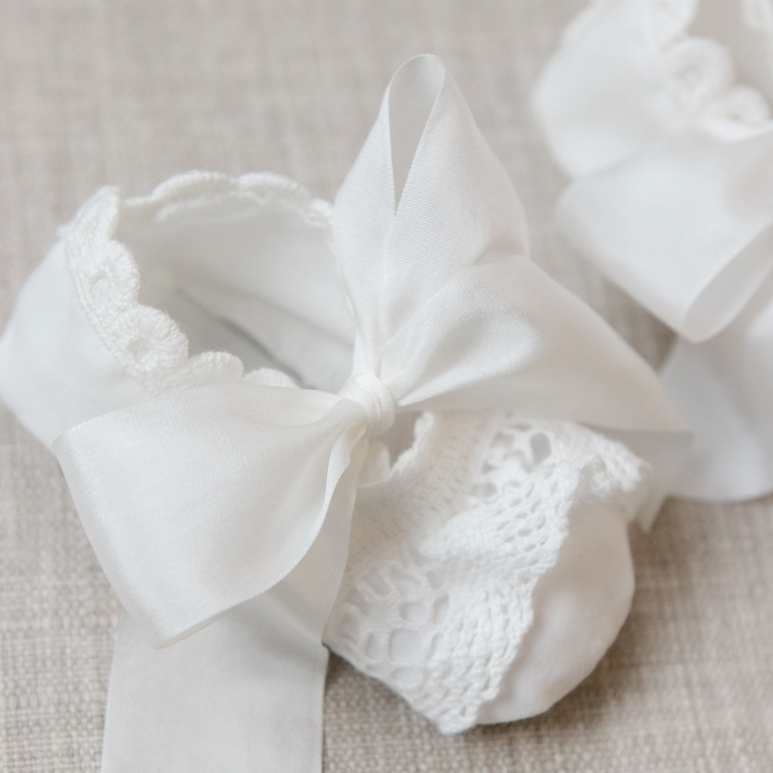 White lace bow on a textured beige background