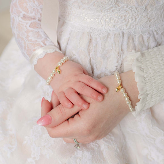 Close-up of Mom and baby wearing pearl bracelets with a soft focus background