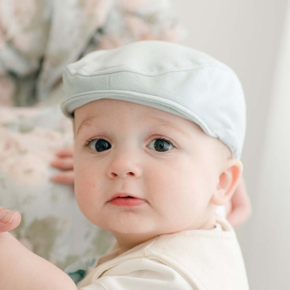 Baby boy wearing an Ezra Powder Blue Newsboy Cap made from soft French terry cotton