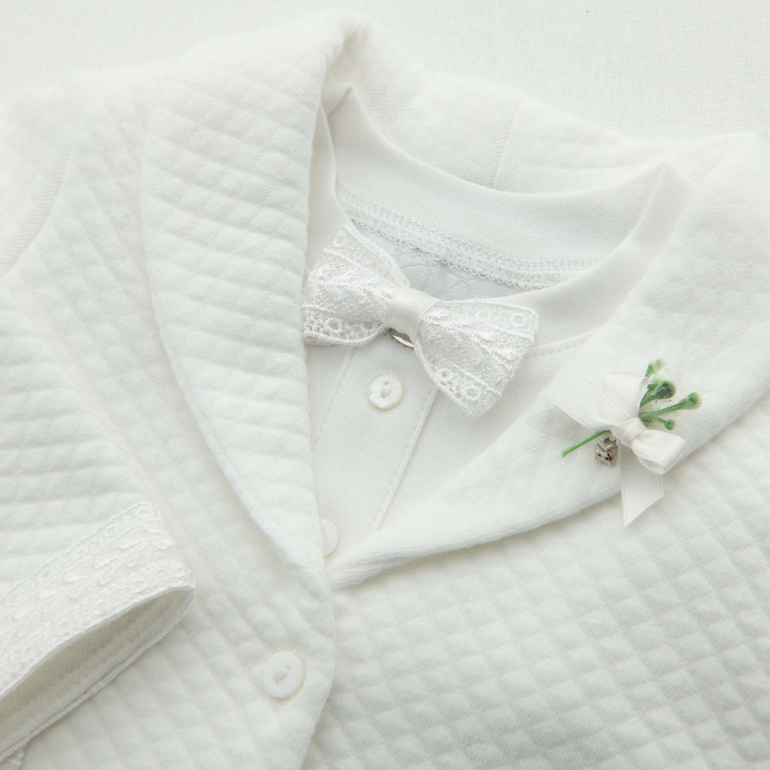 White lace and silk ribbon bow tie on ivory quilt baby suit jacket with matching lace trim