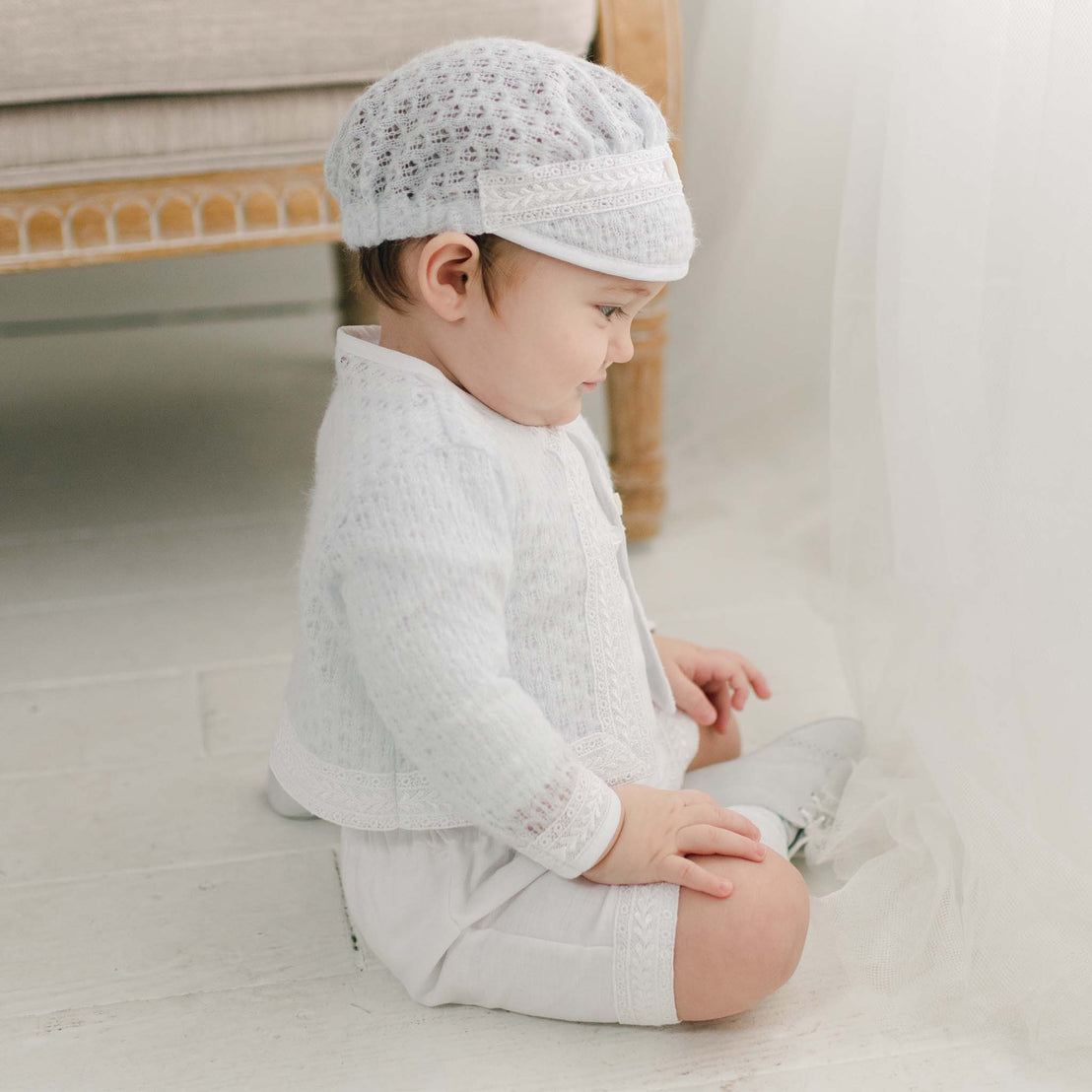 Baby sitting wearing Oliver White Blue Knit Sweater (with matching Blue Knit Hat)