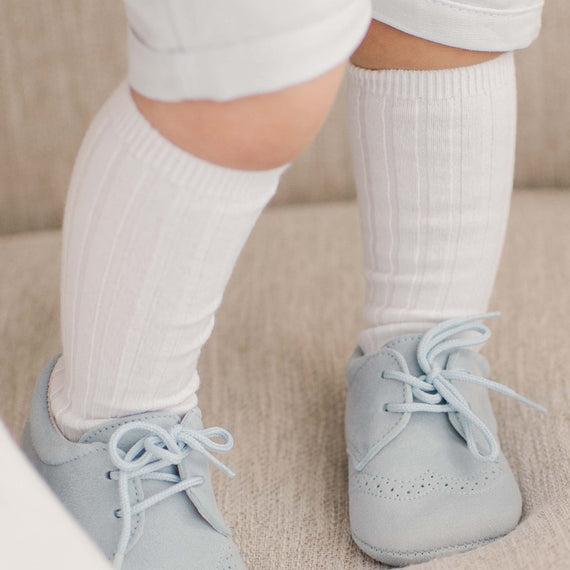 Baby wearing the white Ribbed Knee Socks made from a cotton blend and featuring a ribbed pattern