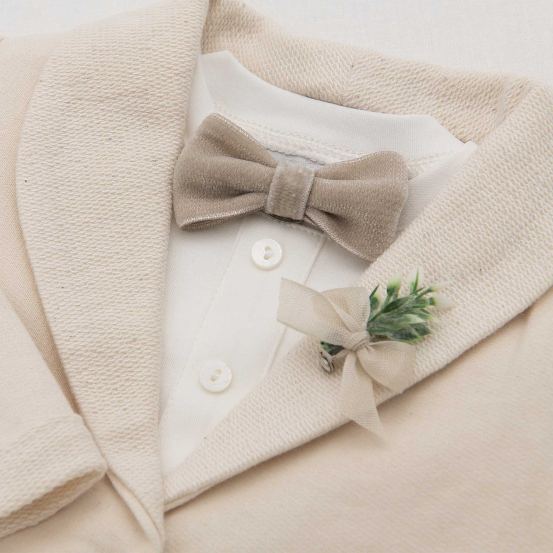 Close up photo of the Braden Velvet Bow Tie & Boutonniere on the Braden Jacket and white onesie
