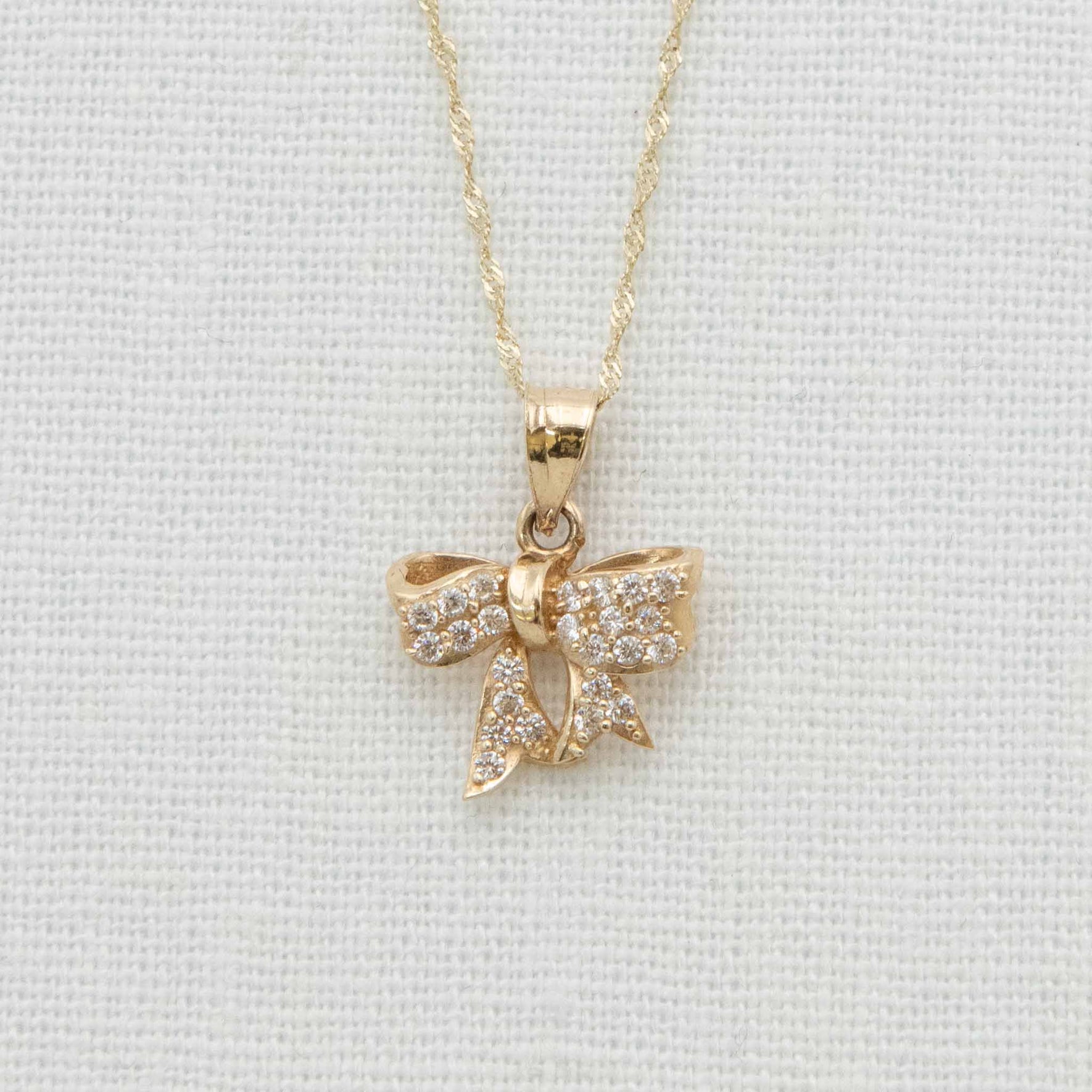 Solid gold bow charm with crystal details on chain