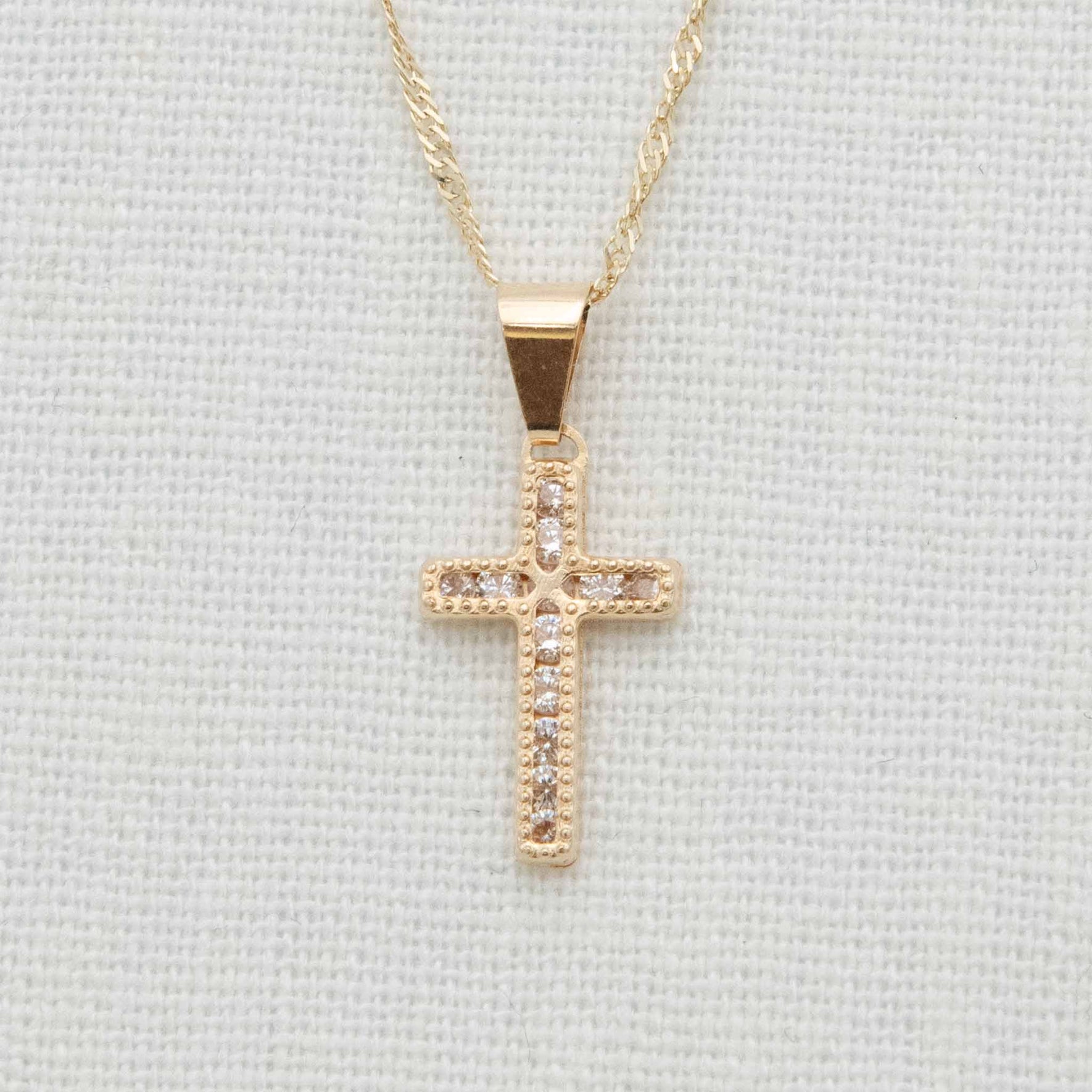 Gold and cubic zirconia cross charm on chain