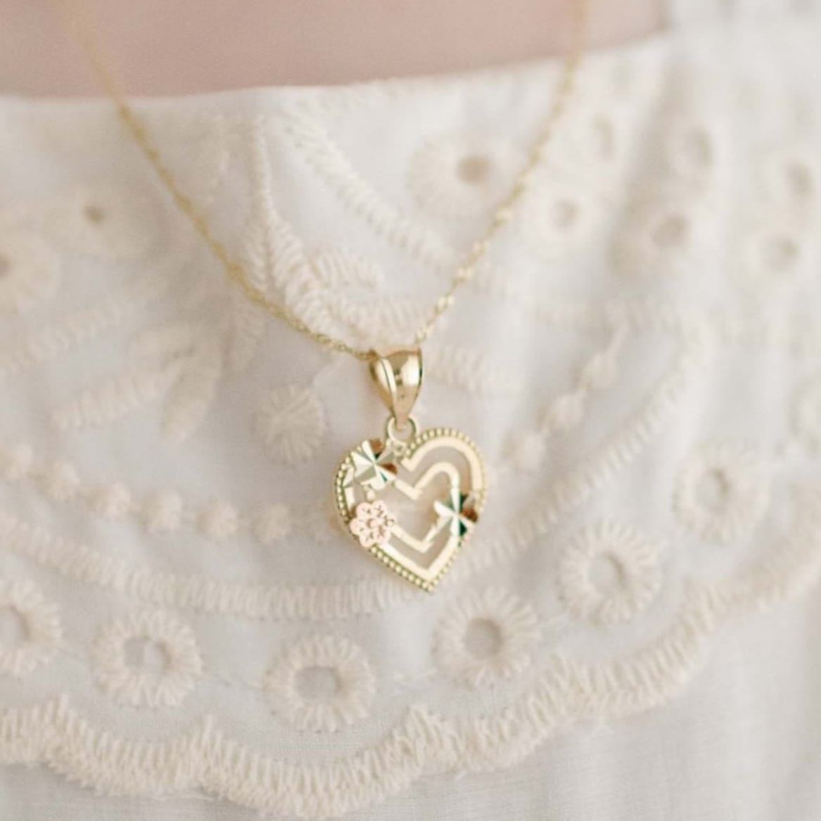 Gold heart charm with gold and rose gold flower details on chain