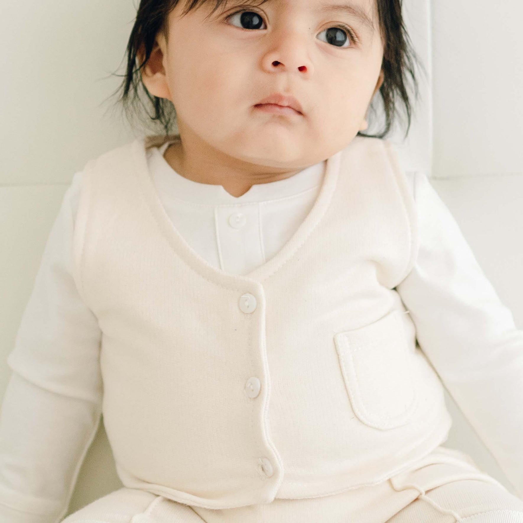 Baby boy wearing the Braden vest with a white onesie underneath