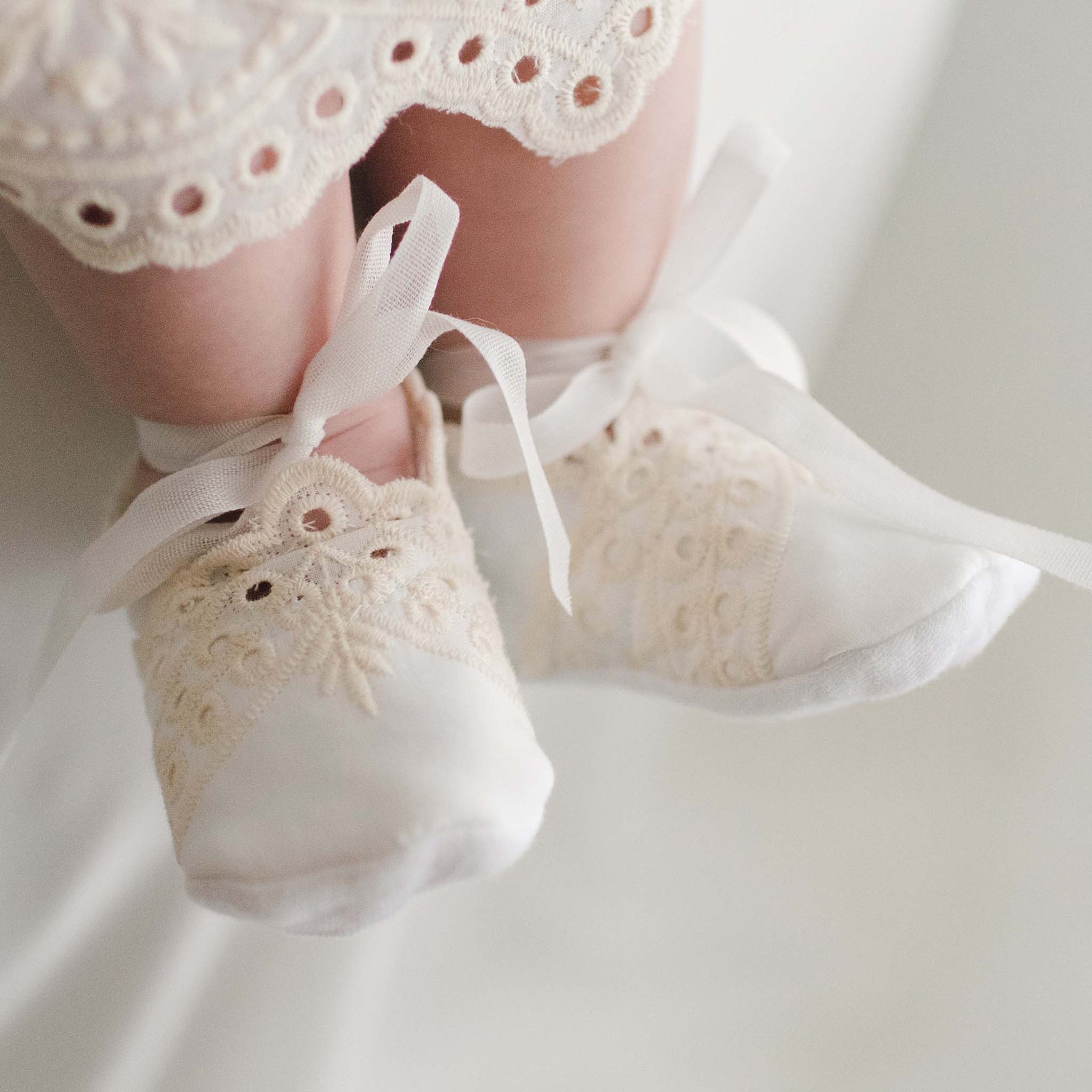 Ingrid Booties made from soft quilted textured cotton and ribbon ties worn by a baby