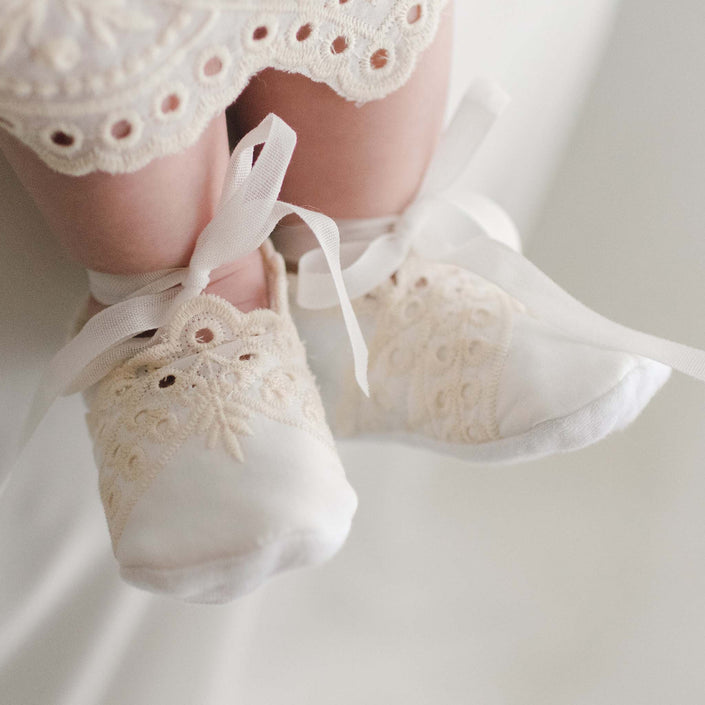 Ingrid Booties made from soft quilted textured cotton and ribbon ties worn by a baby