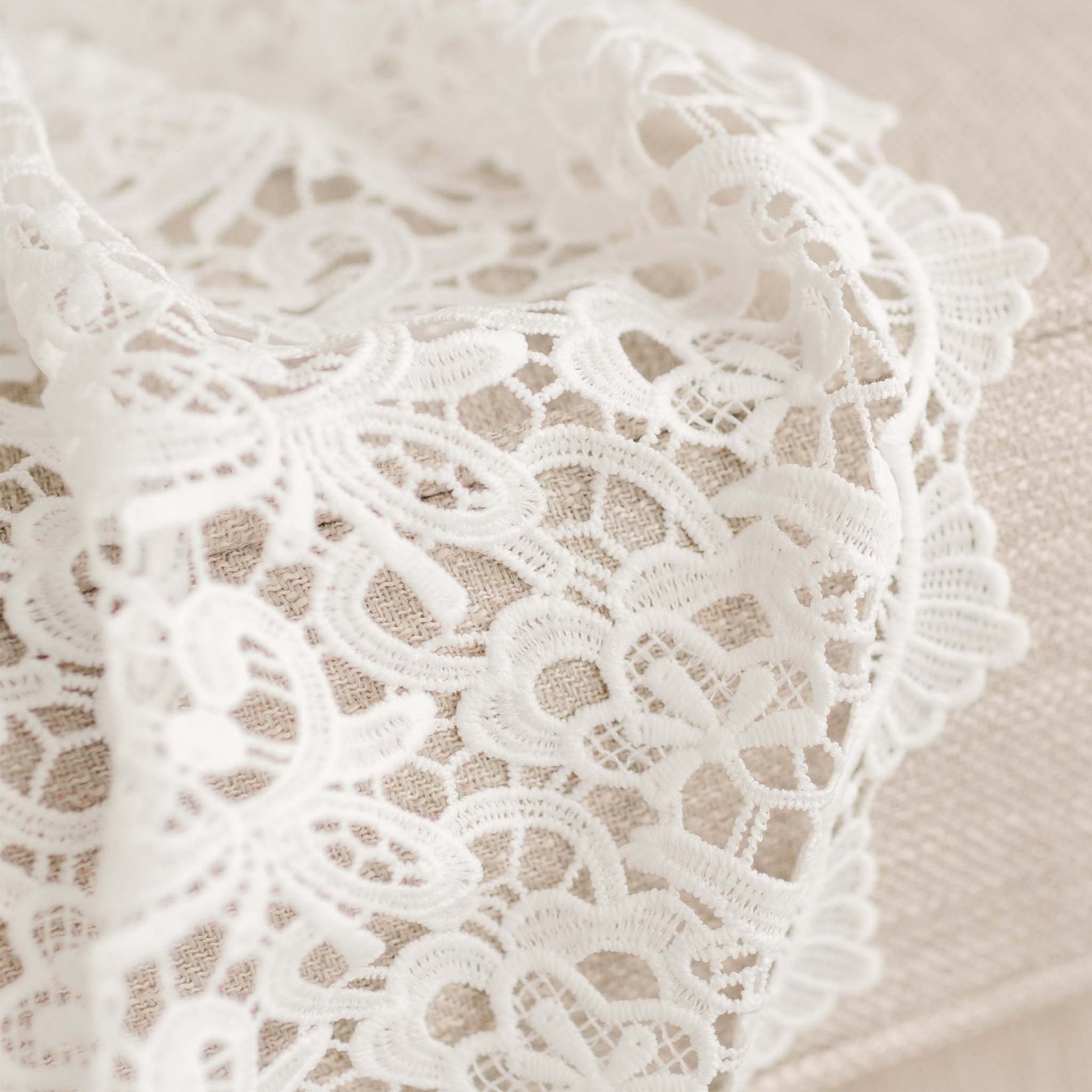 Close up detail of the Lola Baptismal Gown's all-over lace overlay.