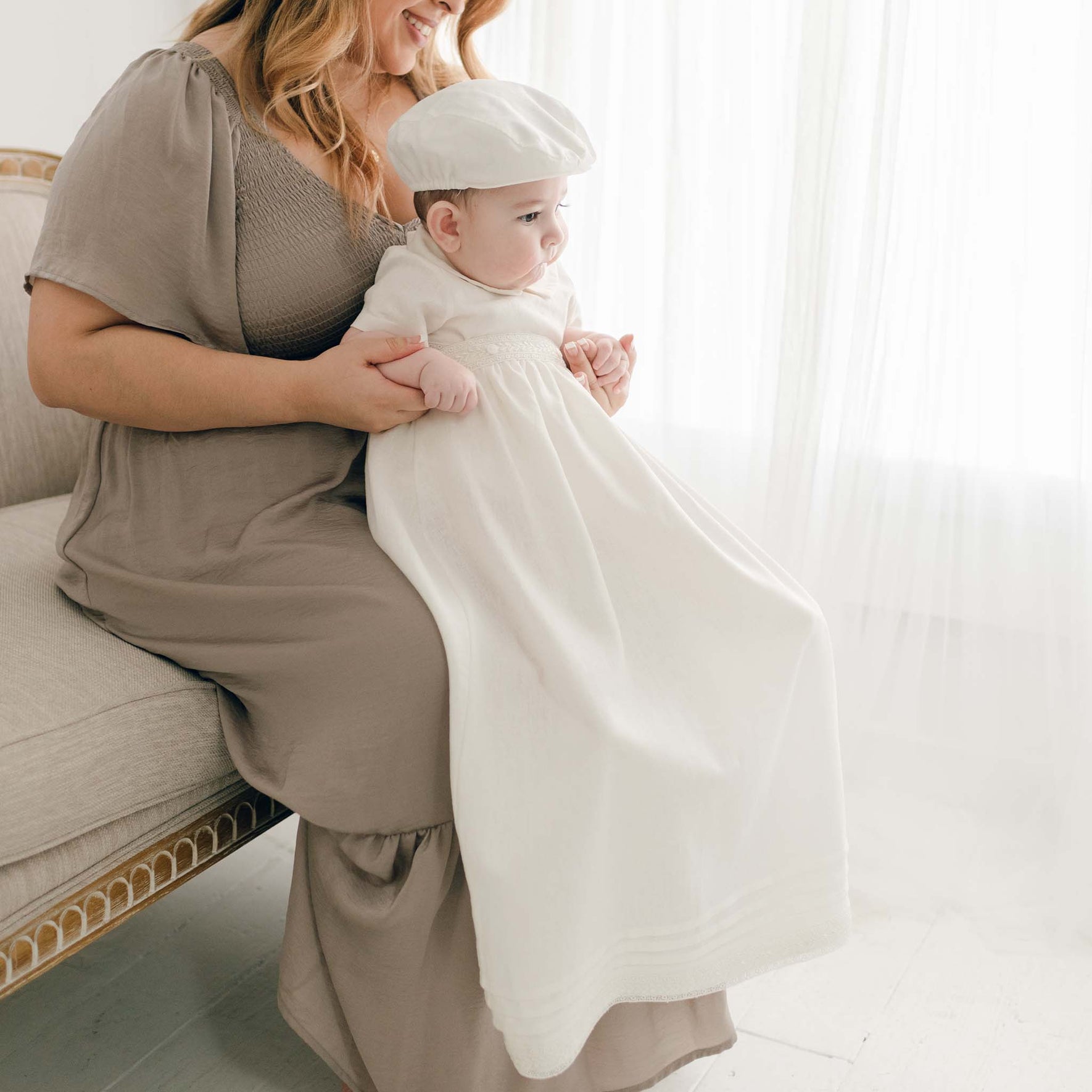 Baby boy wearing the convertible baptism gown and Romper Skirt Set. The skirt attaches to the Oliver Romper to turn the romper into a traditional christening gown.